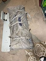 Kayak packed in grey Sea Eagle bag beside transom board