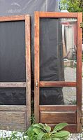 Front view of two wooden screen doors with mesh