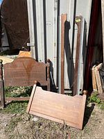 Full view of headboard, footboard, and side rails leaning against structure