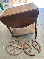 Full view of trolley with leaves folded and broken wooden wheels on floor