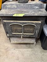 Front view of wood-burning stove showing door, handle and overall appearance