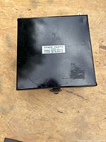 Closed black metal box top view with exterior label