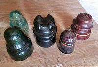 Group of five insulators in assorted colors and materials