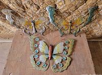 Three metal butterfly wall pieces laid out together