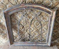 Front view of arched wood frame with metal scrollwork