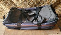 Side view of Timberland rolling duffle showing overall design, twin handles, orange piping