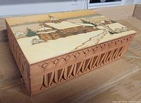 Angled view showing carved sides and pyrography lid scene