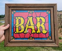 Front view of framed stained glass-style “BAR” picture