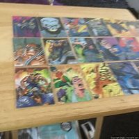 Overall view of the 16 Batman trading cards laid out on tabletop