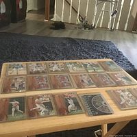All eighteen sleeved baseball cards laid out on a small table