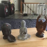All three Buddha statues on tabletop showing relative sizes and finishes