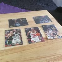 All five basketball trading cards displayed face up on wooden table