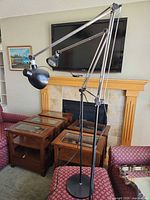 Full view of adjustable floor lamp showing dual heads, articulated chrome arms, black base