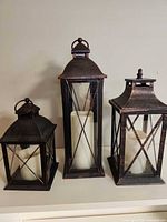 Three antique bronze lanterns with LED candles