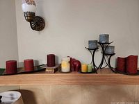 Overall view of mantel with assorted candles, trays, figurine, and candleholder stand