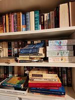 Three shelves of assorted paperback books of varying sizes and genres