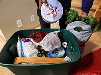 Overview of storage bin, wreath bag, metal tin, ornaments and decorations