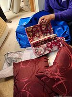 Open floral jewelry box, blue tote, pillows, jewelry bag visible