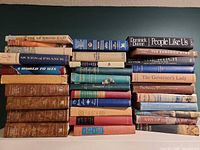 Two tall stacks of assorted vintage hardcover books