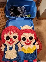 Two hooked yarn doll panels on blue tote