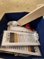 Two sealed Imperial 3 x 10 white ceiling registers in a bin