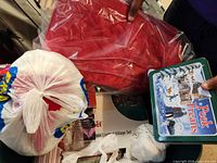 Top view showing red tablecloth, Peek Freans tin, Lemax village box and bagged accessories