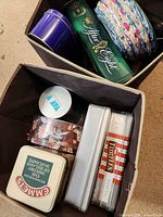 Overview of two storage bins showing multiple decorative tins including After Eight, floral tin, silver tins, Emmets, Turtles