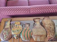 All six metal vase plaques displayed side-by-side