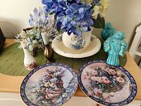 Overall view of plates, birds, pitcher set, bud vase, candlestick, flowers