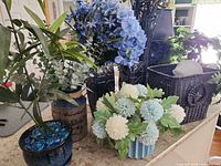 Group shot of all planters, vases, basket and floral arrangements on countertop
