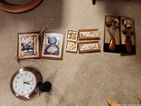 All pieces laid out on carpet: clock, bear plaques, floral panels, small floral boxes