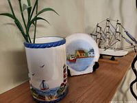 Ceramic vase, agate plaque and sailboat displayed together