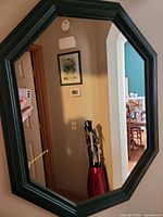 Front view showing octagonal shape, dark green frame, reflective glass