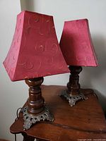 Pair of lamps on table showing overall style, wood columns and metal bases