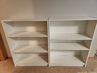 front view of both white bookcases showing shelves
