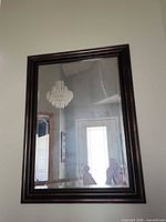 Front view of rectangular dark brown/antique bronze framed wall mirror