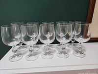 Front view of all ten clear crystal goblets on surface