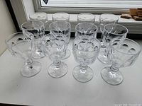 Front angled view of 12 clear glass wine goblets on surface