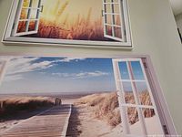 Both canvas prints hung, showing beach window scenes