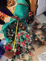 Overall lot with green storage bag, two wreaths and garland visible, tape measure showing size