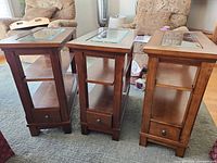 Three mission-style wood and glass end tables front view