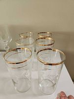 Group of six glasses showing etched pattern and gold rims