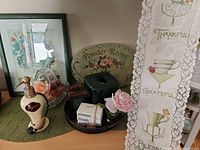 Group view showing framed print, sign, banner, tissue cover, soap dispenser, lantern, faux flower, wood block sign, tray