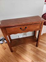 Front view of solid oak console table showing drawer, lower shelf and legs