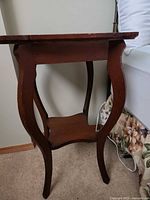 Full view of oak veneer end table showing top, legs, and lower shelf