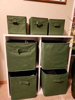 Front view of white 6-cube shelf with six green fabric bins inserted