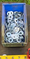 Top view of blue bin filled with flat washers