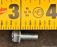 close-up of single fluted 3/8 inch hex head screw beside ruler for scale