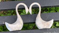 Front view of both cast metal swans facing to form heart shape