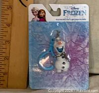Front view of Olaf bag clip sealed on Frozen card with size reference